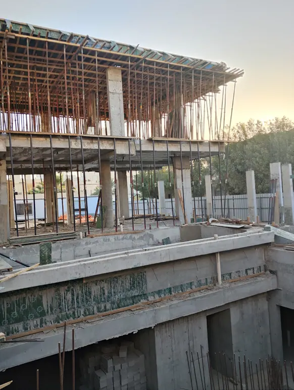 طابق علوي بدعامات خشبية عند الغروب، فوق جدران وأعمدة خرسانية.